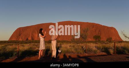 22 aprile 2014 - Yulara, Australia - il PRINCIPE britannico WILLIAM, Right, e sua moglie KATE MIDDLETON, duchessa di Cambridge, chiacchierano prima di posare per una foto davanti al monolito di arenaria rosso brillante Uluru, noto anche come Ayers Rock. William e Kate hanno ricevuto un tradizionale benvenuto aborigeno durante una visita all'Outback australiano. (Immagine di credito: © William West/Pool/Prensa Internacional/ZUMAPRESS.com) Foto Stock
