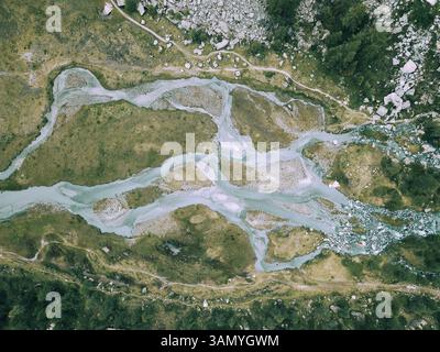 Veduta aerea di un fiume rivuleti che trasportano sedimenti dal ghiacciaio, la valle preda Rossa, la Val Masino, Italia. Foto Stock