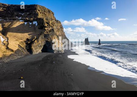 Vista aerea della gente di Reynisfjara, una spiaggia di sabbia nera lungo la costa islandese. Foto Stock