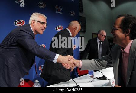 28 aprile 2014 - Raleigh, NC, Stati Uniti - l'arrivo del General Manager dei Carolina Hurricanes Ron Francis, a sinistra, riceve le congratulazioni, dopo che il proprietario della squadra Peter Karmanos, centro sinistro, e il General manager uscente, Jim Rutherford, centro destro, ha annunciato un cambio di direzione alla PNC Arena di Raleigh, N.C. lunedì 28 aprile 2014. (Immagine di credito: © Chris Seward/MCT/ZUMAPRESS.com) Foto Stock