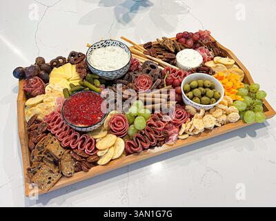 Questo vivace tagliere di salumi offre un mix di spuntini salati, dolci e croccanti, perfetti per feste, riunioni o serate intime. Foto Stock