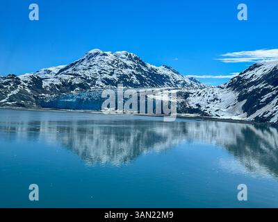 Una splendida vista di un ghiacciaio dell'Alaska, dove il ghiaccio incontra il cielo e l'acqua in uno spettacolo mozzafiato della potenza della natura. Foto Stock