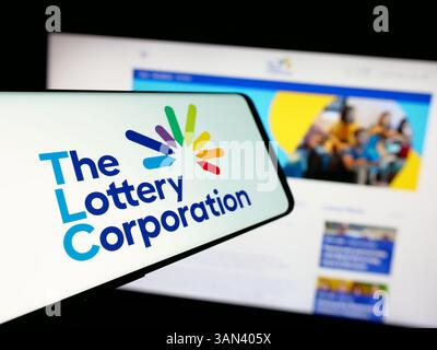 Stoccarda, Germania - 12-03-2024: Smartphone con logo della società australiana Lottery Corporation Limited sullo schermo davanti al sito Web. Foto Stock