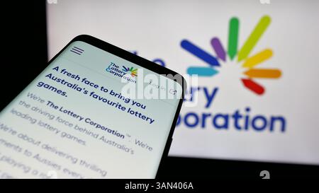 Stoccarda, Germania - 12-03-2024: Telefono cellulare con sito web della società australiana Lottery Corporation Limited sullo schermo davanti al logo. Foto Stock