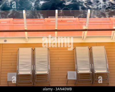 Lettini sul ponte delle navi da crociera con mare e onde che passano, tramonto Foto Stock