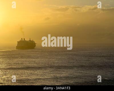 La nave da crociera naviga verso il tramonto Foto Stock