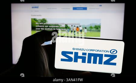 Stoccarda, Germania - 12-03-2024: Persona che detiene un telefono cellulare con sullo schermo il logo della società giapponese di ingegneria Shimizu Corporation Foto Stock