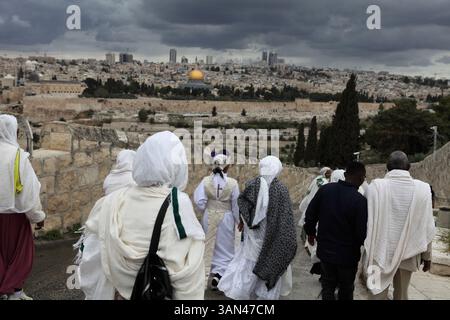 Processione della domenica delle Palme, pellegrini cristiani etiopi a piedi dal Monte Olive che commemorano la corsa di Cristo a Gerusalemme, la Cupola della roccia vista nel retro. Foto Stock