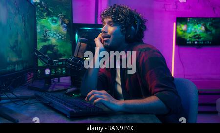 L'indiano arabo annoiato uomo assonnato sbadigliando giocando a tipire il computer maschio prende le cuffie parlando rispondere giocatore stanco affaticato streamer tardi Foto Stock