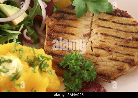 Maiale con zucca e insalata di arancia e barbabietole e avocado Foto Stock