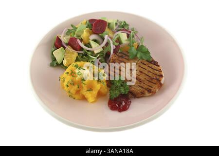 Maiale con zucca e insalata di arancia e barbabietole e avocado Foto Stock