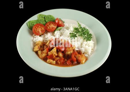 Stufato speziato di lenticchie di pollo e pepe con riso e insalata fresca Foto Stock