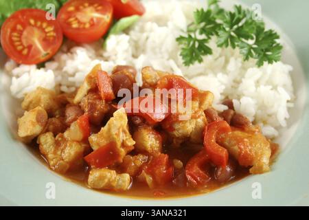 Stufato speziato di lenticchie di pollo e pepe con riso e insalata fresca Foto Stock