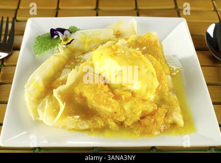 Deliziose crepe all'arancia con gelato agli agrumi e crema pasticcera Foto Stock