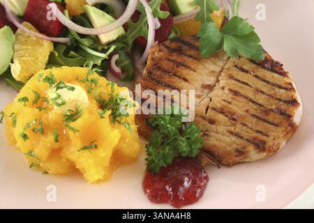 Maiale con zucca e insalata di arancia e barbabietole e avocado Foto Stock