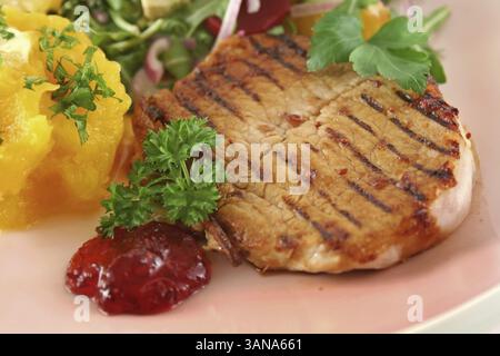 Maiale con zucca e insalata di arancia e barbabietole e avocado Foto Stock