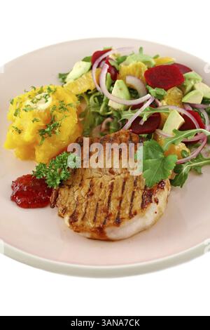 Maiale con zucca e insalata di arancia e barbabietole e avocado Foto Stock