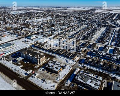 Paesaggio urbano innevato con un grande complesso di appartamenti nel centro. Gli edifici sono per lo più vuoti e la neve copre il terreno Foto Stock