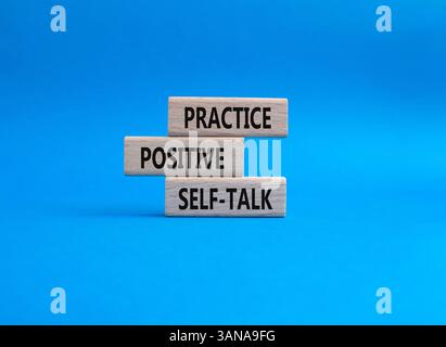Esercitarsi con il simbolo di autoapprendimento positivo. Le parole concettuali esercitano un'autocomunicazione positiva su blocchi di legno. Bellissimo sfondo blu. Deposito per affari e pratica Foto Stock