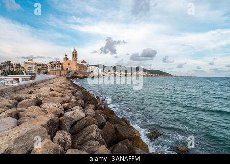 Molo roccioso che conduce all'iconica chiesa di Sitges, in Spagna Foto Stock
