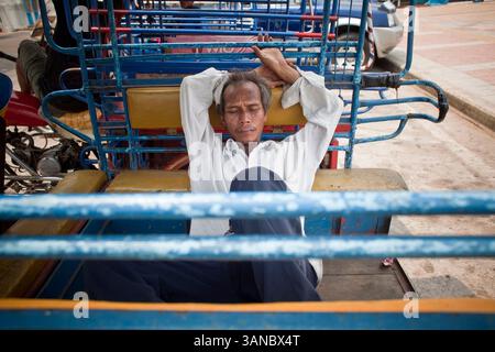 6 aprile 2010 - That Phanom, Nakhon Phanom, Thailandia - Un autista di tuk tuk dorme nel suo tuk tuk a Nakhon Phanom, Thailandia. I tuk tuk sono taxi a tre ruote alimentati da motociclette comuni nel sud-est asiatico. I tuk tuk a Nakhon Phanom sono chiamati skylabs dalla popolazione locale. (Immagine di credito: © Jack Kurtz/ZUMA Press) Foto Stock