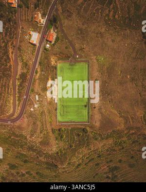 Veduta aerea di uno splendido stadio di calcio circondato da campi e alberi verdi, Vallehermoso, Spagna. Foto Stock