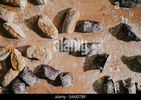 Un tavolo coperto di vari tipi di ciambelle, tra cui alcune con glassa blu. Le ciambelle sono ricoperte di zucchero a velo, donando loro un dolce e un dolce Foto Stock