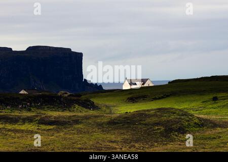 scogliere buie, cieli spettacolari, mare, casa bianca, erba illuminata dal sole, atmosferico Foto Stock