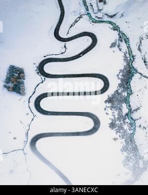 Vista aerea del paesaggio invernale innevato con strade e foreste vuote, passo Julier, Grigioni, Svizzera. Foto Stock
