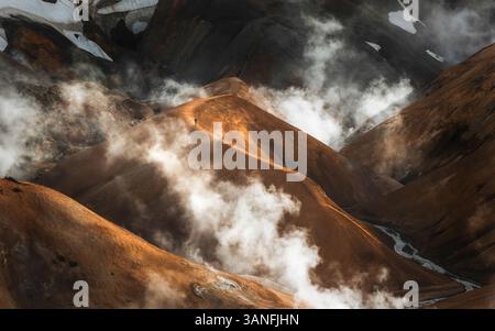 Vista aerea delle maestose montagne rocciose con vapore e nuvole spettacolari, Kerlingarfjoll, Kjolur, Islanda. Foto Stock