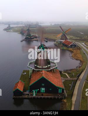 Vista aerea dei tradizionali mulini a vento ed edifici pittoreschi lungo il fiume in un paesaggio tranquillo, Zaanse Schans, Paesi Bassi. Foto Stock