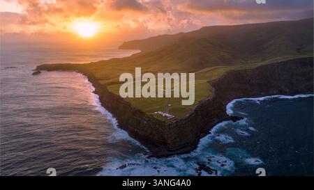 Vista aerea di un bellissimo faro all'alba su una scogliera aspra che si affaccia sull'oceano, Farol de Albarnaz, Azzorre. Foto Stock