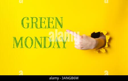 Mano che indica la parola lunedì verde su sfondo giallo. Concetto di urgenza o importanza, come se lo spettatore venisse indirizzato a prestare attenzione Foto Stock