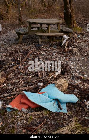 Presso una panchina da picnic in legno sulla riva della baia di Fearnoch, la spazzatura è bagnata da un'alta marea invernale. Argyll e Bute, Scozia Foto Stock