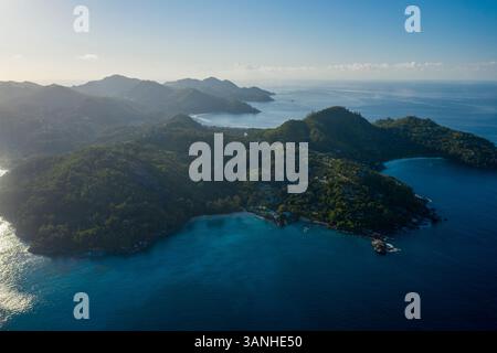 Vista aerea panoramica della splendida costa durante una splendida giornata vicino a Grand'Anse Mahé, Seychelles. Foto Stock