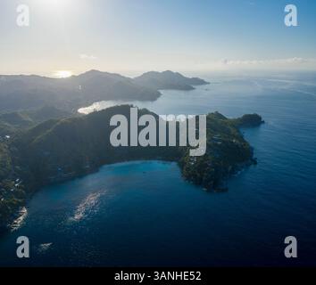 Vista aerea panoramica della splendida costa durante una splendida giornata vicino a Grand'Anse Mahé, Seychelles. Foto Stock