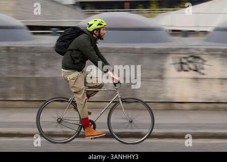 Un uomo che pedala su una bicicletta a una velocità attraverso il Waterloo Bridge, Londra, Regno Unito. 12 aprile 2025 Foto Stock