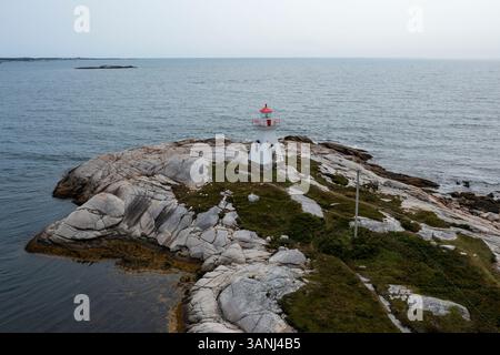 Vista aerea del tranquillo paesaggio costiero con un faro e una costa rocciosa, Terence Bay, Canada. Foto Stock