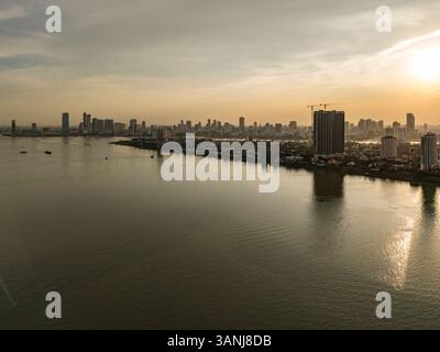 Vista aerea del tranquillo tramonto sul fiume con moderni grattacieli che si riflettono sull'acqua, Chroy Changvar, Phnom Penh, Cambogia. Foto Stock