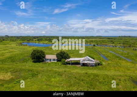 Vista aerea di una fattoria abbandonata vicino alla Old Dixie Highway con un lago sullo sfondo, St. Lucie County, Florida, Stati Uniti. Foto Stock