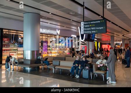 Regno Unito, Inghilterra, aeroporto di Manchester, sala partenze Terminal 2, passeggeri in attesa al negozio Duty Free Foto Stock