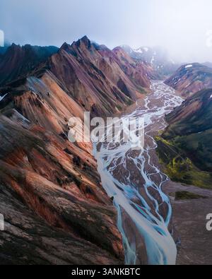 Vista aerea delle maestose montagne e di un fiume tortuoso in una valle mozzafiato, Highlands, Islanda. Foto Stock