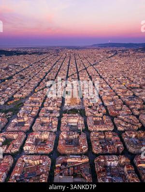 Vista aerea della splendida Basilica de la Sagrada Familia in mezzo a un vasto paesaggio urbano al tramonto, Barcellona, Spagna. Foto Stock