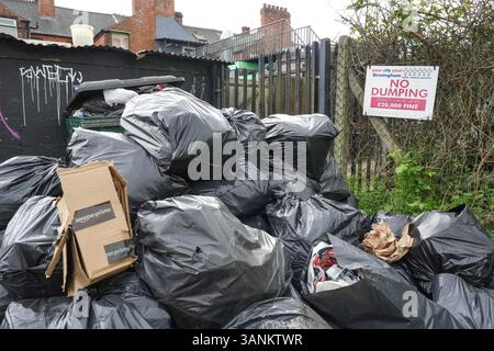 Spring Road, Acocks Green, Birmingham, 15 aprile 2025: Mentre i lavoratori dei rifiuti continuano a scioperare con il sostegno dell'Unione Unite, le aree di Birmingham soffrono ancora perché i rifiuti vengono lasciati fuori dalle case e dalle imprese. Una grande pila di sacchetti è stata lasciata di fronte a un cartello "No dumping" che avverte di multe fino a 20.000 kg su Spring Road, nella zona di Acocks Green della città. Crediti: British News and Media/Alamy Live News Foto Stock