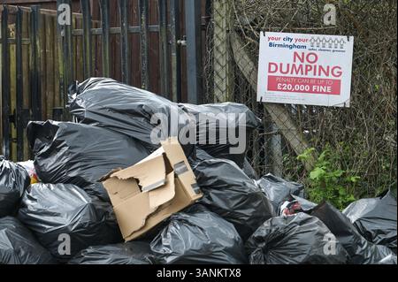 Spring Road, Acocks Green, Birmingham, 15 aprile 2025: Mentre i lavoratori dei rifiuti continuano a scioperare con il sostegno dell'Unione Unite, le aree di Birmingham soffrono ancora perché i rifiuti vengono lasciati fuori dalle case e dalle imprese. Una grande pila di sacchetti è stata lasciata di fronte a un cartello "No dumping" che avverte di multe fino a 20.000 kg su Spring Road, nella zona di Acocks Green della città. Crediti: British News and Media/Alamy Live News Foto Stock