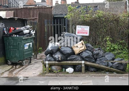 Spring Road, Acocks Green, Birmingham, 15 aprile 2025: Mentre i lavoratori dei rifiuti continuano a scioperare con il sostegno dell'Unione Unite, le aree di Birmingham soffrono ancora perché i rifiuti vengono lasciati fuori dalle case e dalle imprese. Una grande pila di sacchetti è stata lasciata di fronte a un cartello "No dumping" che avverte di multe fino a 20.000 kg su Spring Road, nella zona di Acocks Green della città. Crediti: British News and Media/Alamy Live News Foto Stock