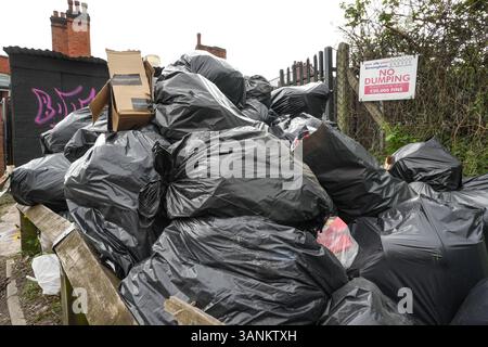Spring Road, Acocks Green, Birmingham, 15 aprile 2025: Mentre i lavoratori dei rifiuti continuano a scioperare con il sostegno dell'Unione Unite, le aree di Birmingham soffrono ancora perché i rifiuti vengono lasciati fuori dalle case e dalle imprese. Una grande pila di sacchetti è stata lasciata di fronte a un cartello "No dumping" che avverte di multe fino a 20.000 kg su Spring Road, nella zona di Acocks Green della città. Crediti: British News and Media/Alamy Live News Foto Stock