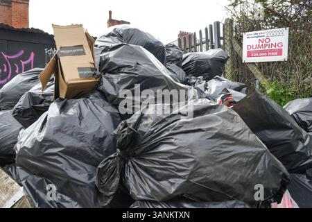 Spring Road, Acocks Green, Birmingham, 15 aprile 2025: Mentre i lavoratori dei rifiuti continuano a scioperare con il sostegno dell'Unione Unite, le aree di Birmingham soffrono ancora perché i rifiuti vengono lasciati fuori dalle case e dalle imprese. Una grande pila di sacchetti è stata lasciata di fronte a un cartello "No dumping" che avverte di multe fino a 20.000 kg su Spring Road, nella zona di Acocks Green della città. Crediti: British News and Media/Alamy Live News Foto Stock