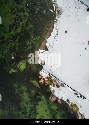 Vista aerea della costa innevata e del mare verde dell'Estonia. Foto Stock
