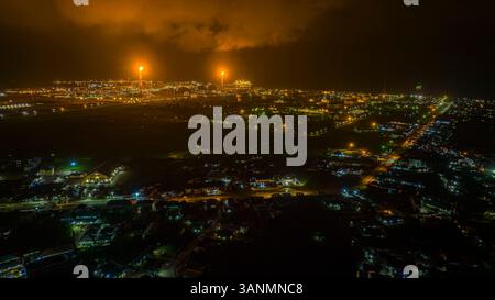 Vista aerea della raffineria illuminata e del paesaggio urbano di notte, Bonny, Nigeria. Foto Stock